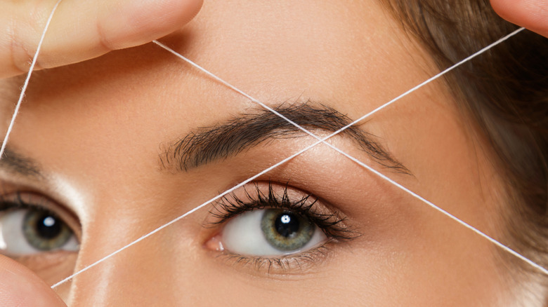 woman threading eyebrows
