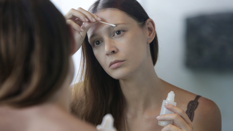 woman applying hair growth serum