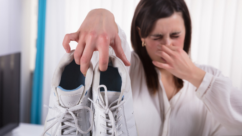 woman with shoes plugging nose