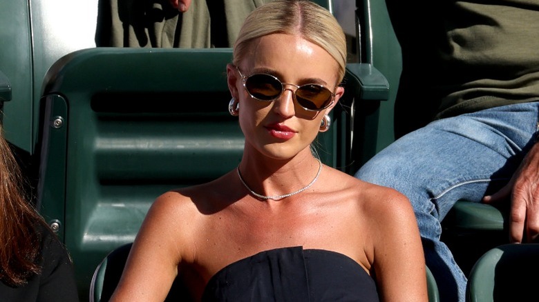 Morgan Riddle sits in the sun watching the Indian Wells tennis tournament