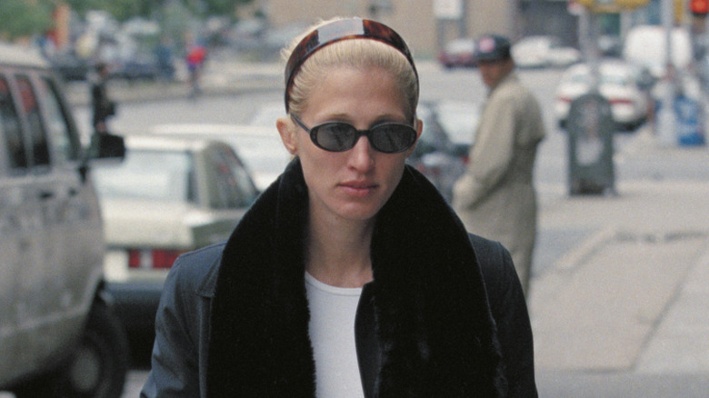 Carolyn Bessette-Kennedy walking with a tortoiseshell headband and glasses