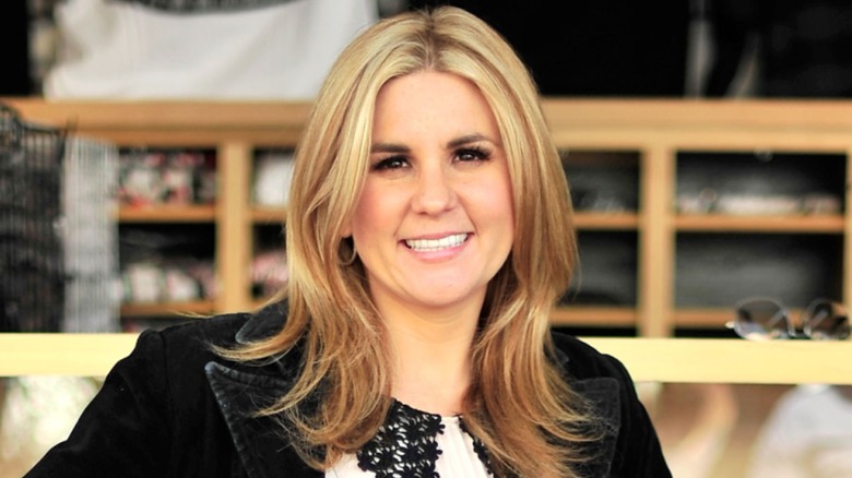 Brandi Passante is a woman with fair skin and blonde hair. In this image, she's wearing a black blazer and a white top with black flowers.