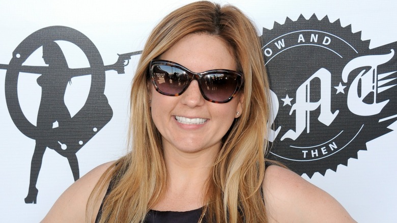 Brandi Passante at an event. In this image, she's wearing a pair of black and brown sunglasses and a black tank top.