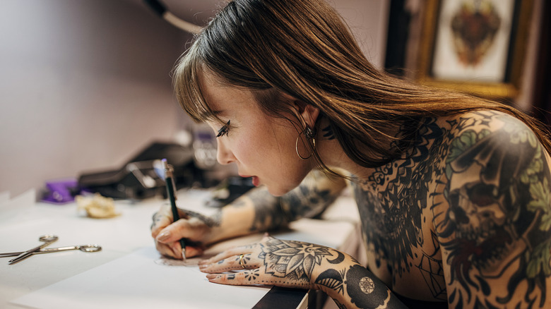 Female tattoo artist sketching 