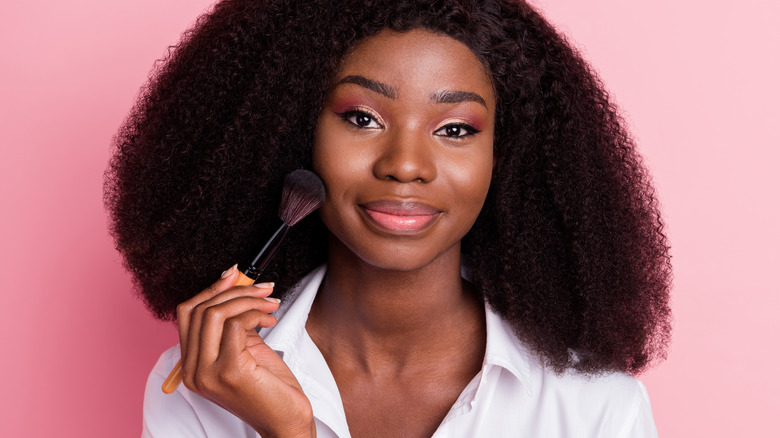 Woman applying makeup with a brush