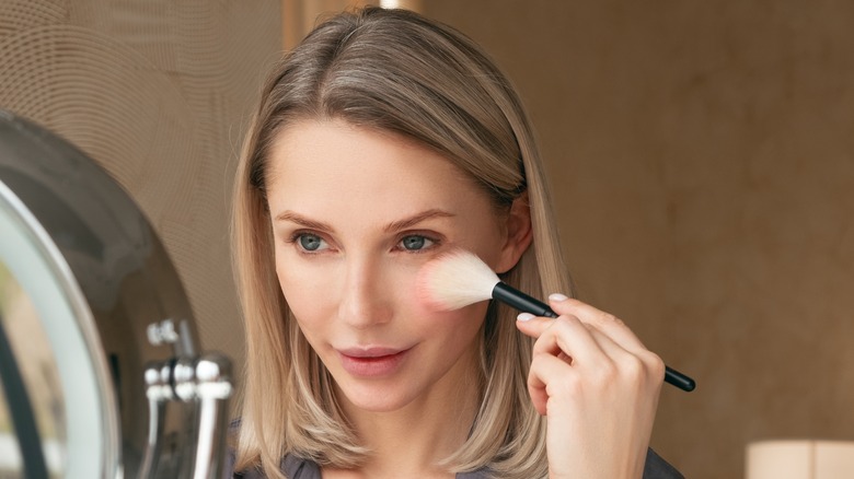Woman putting on makeup