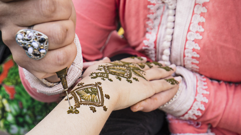 person getting henna tattoo