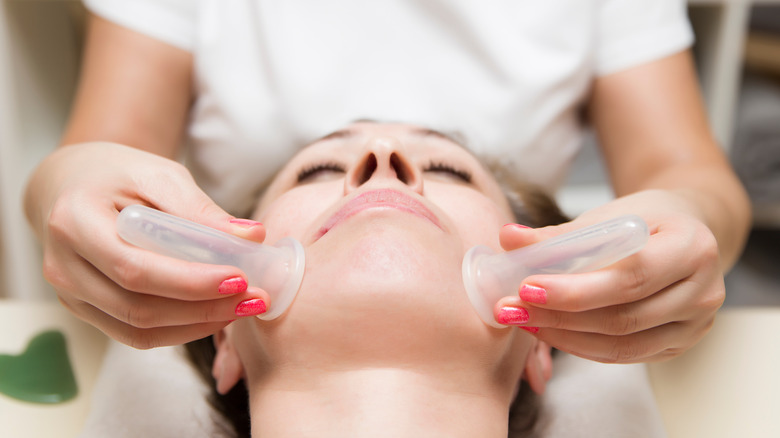 Woman getting face cupping treatment