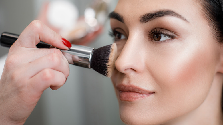 woman applying highlighter 