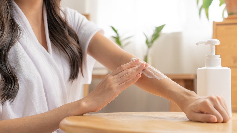 person moisturizing arm