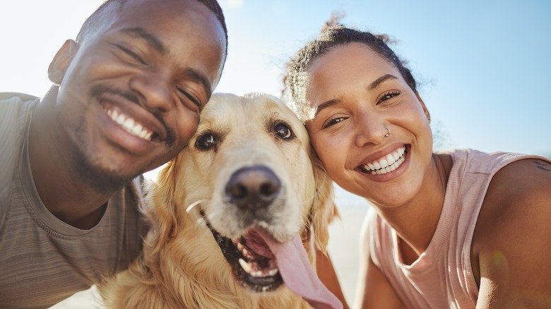 Smiling happy couple with dog