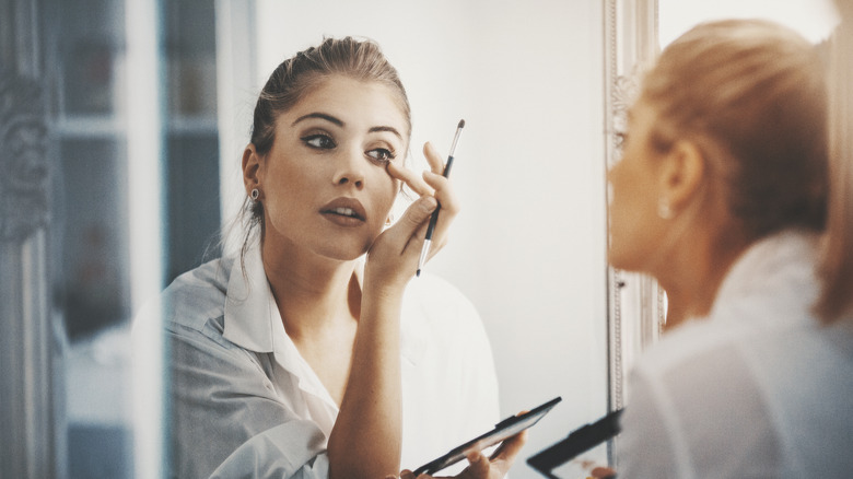 Woman applying eye makeup