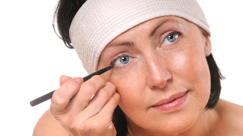 Woman applying eyeiner