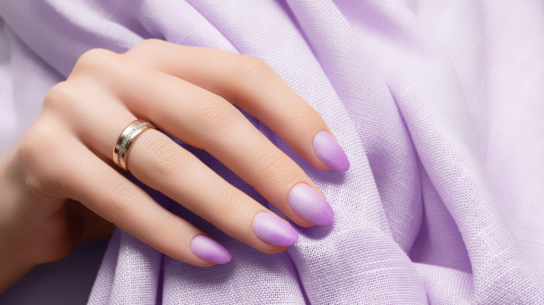 woman with purple glitter nail design