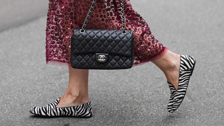A woman walking in animal print loafters