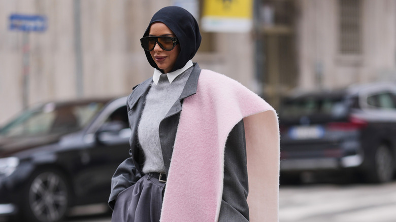 A woman wears a fall beanie and a scarf