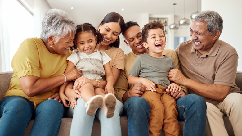 Family laughing together sitting at the couch