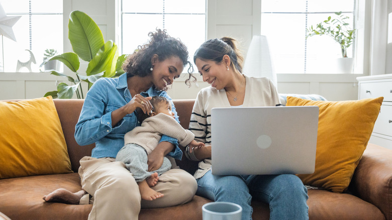 Two women smiling at a baby