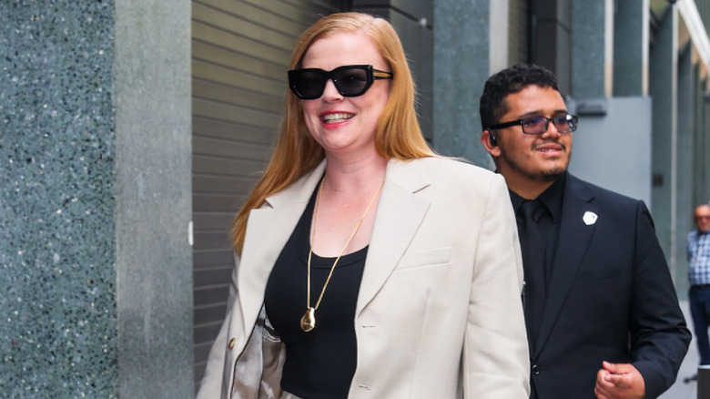 A woman wearing large sunglasses with a suit