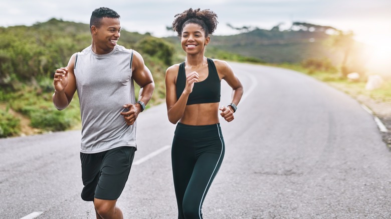 Man and woman running together outside