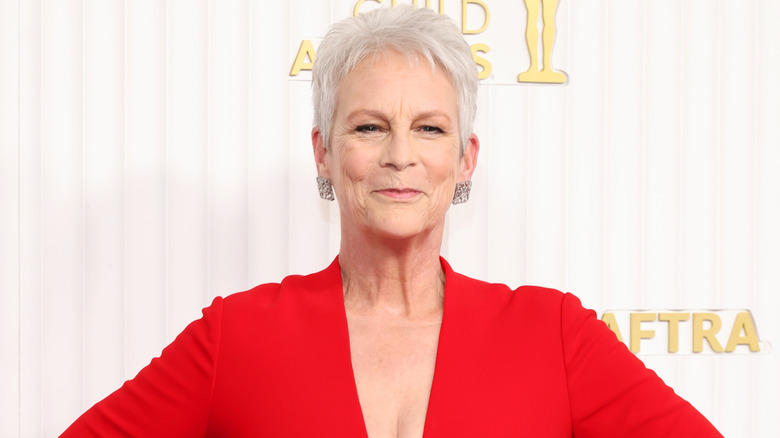 Jamie Lee Curtis wears a low-cut red gown on the red carpet