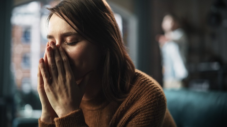 girl crying partner in background