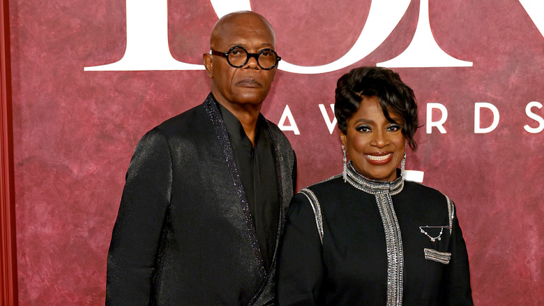 Samuel L. Jackson in a metalic black suit standing next to wife LaTanya Richardson wearing a black and silver dress.
