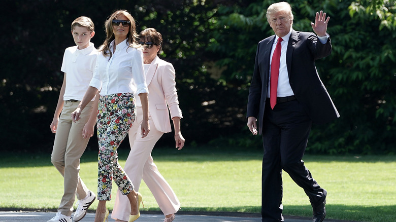 Melania Trump with Barron Trump, Donald Trump, and her mother in floral pants and a white shirt