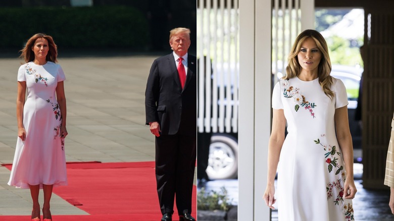 Melania Trump standing with Donald Trump in a white floral dress