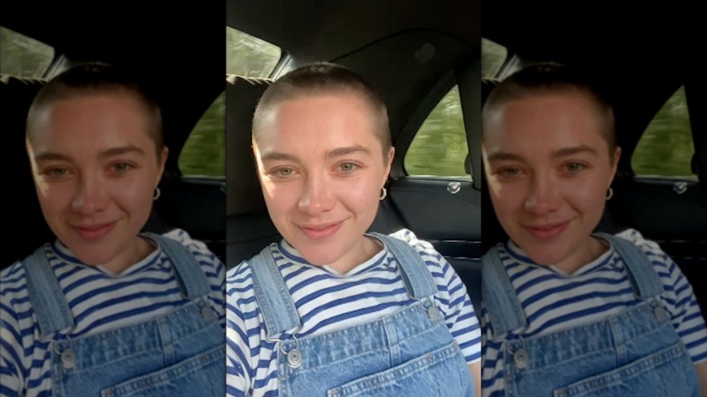 Florence Pugh with a buzz cut in a car