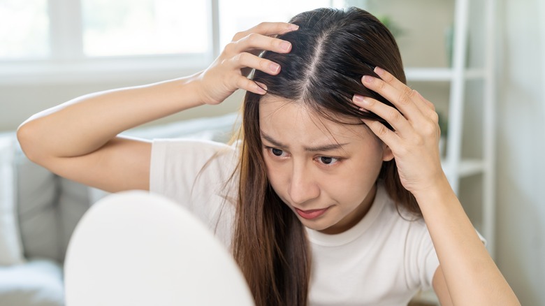 woman looking at her hair 