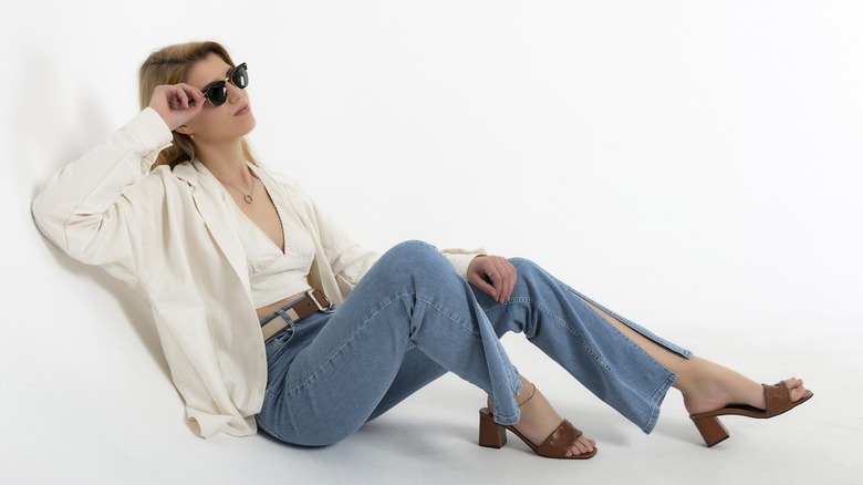 A woman wearing blue jeans with a split hem.