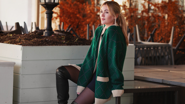 A woman wearing a green oversized cardigan