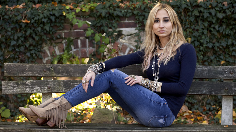 A woman wearing skinny jeans and ankle boots outside