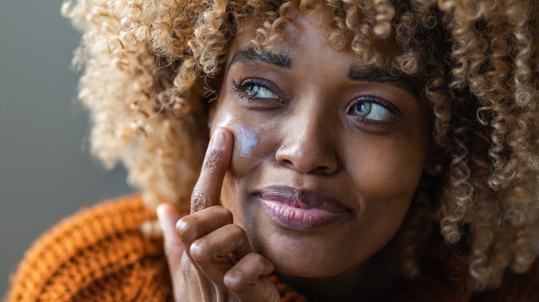 Woman applying skin product