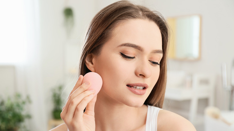 Woman applying foundation with sponge