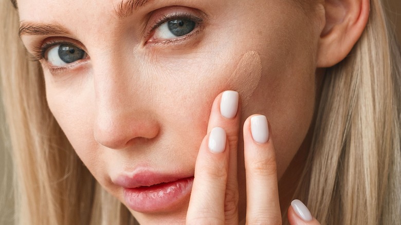 woman applying foundation