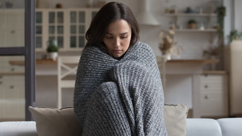 Tense woman wrapped in a blanket
