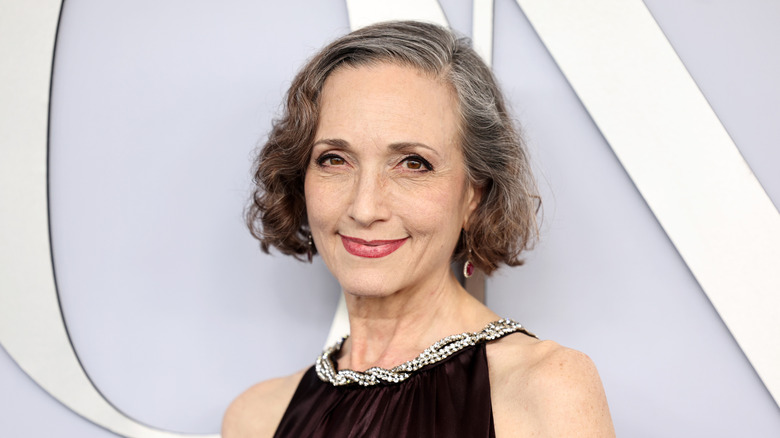 Bebe Neuwirth on the red carpet in 2024 wearing an elegant black dress with a rhinestone-decorated neckline.