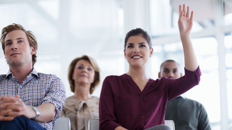 person raising hand to ask question