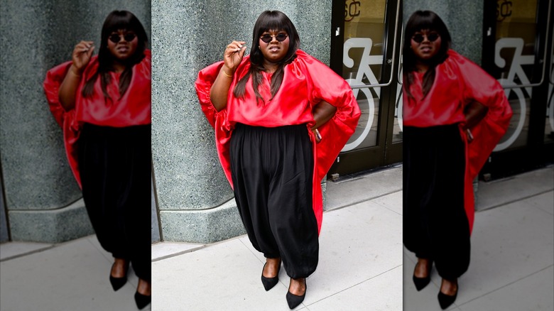 Gabourey Sidibe wearing a red shirt and blackpants