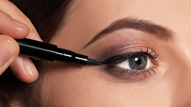 woman applying eyeliner