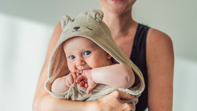 A mother holding her baby in a hooded bath blanket