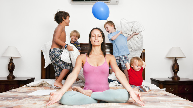 woman meditating with family in background
