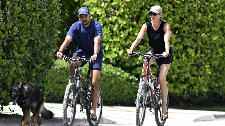 Gisele Bündchen rides a bike alongside Joaquim Valente.