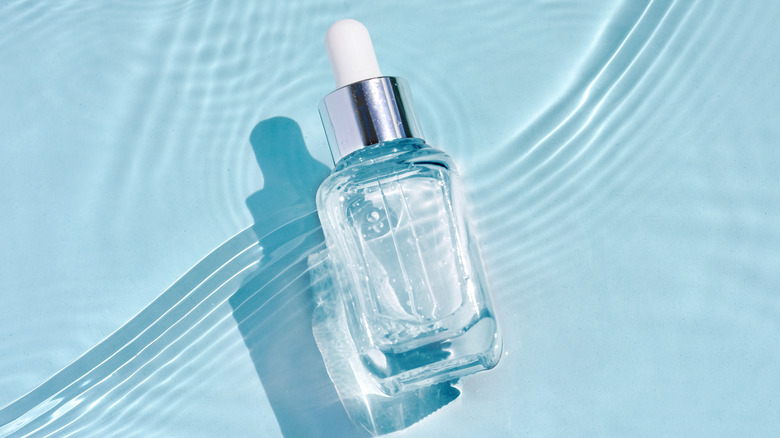 Luxury skincare glass bottle in water