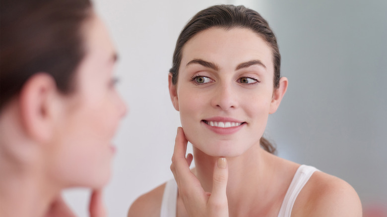 Woman admires skin in mirror
