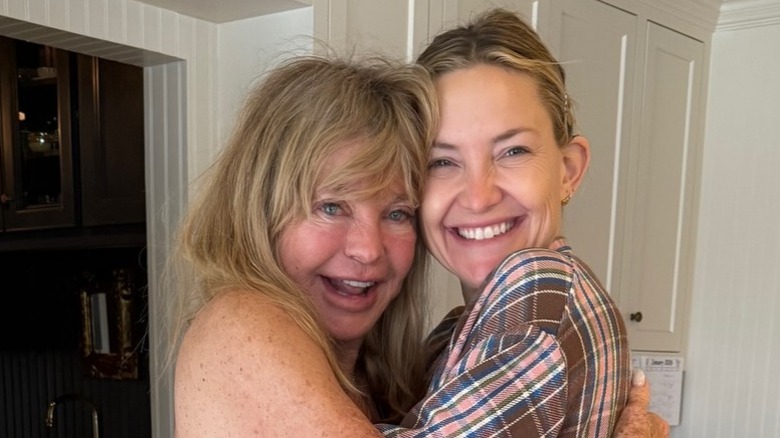 Goldie Hawn and Kate Hudson hugging and smiling in a candid photo.