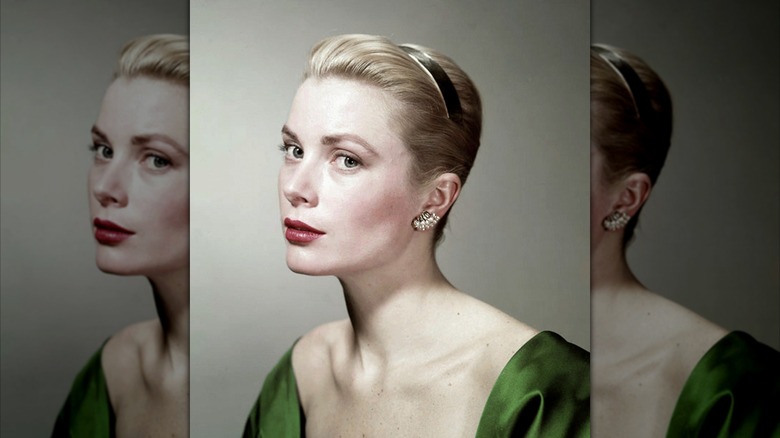 Grace Kelly posing in a green top with pearl earrings and her hair up with a headband.