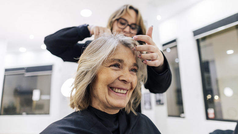 A woman has her gray hair treated at a salon